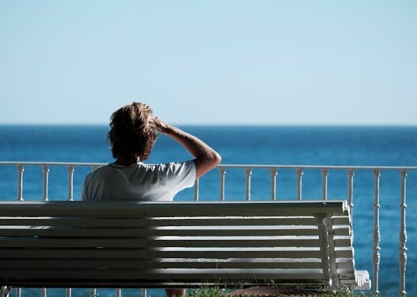 person sitting on bench looking at horizon