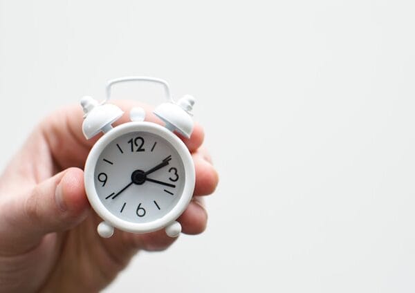 hand holding alarm clock